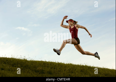Caucasian runner running in field Stock Photo