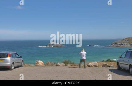 A tourist takes a photograph at Crantock Bay in Cornwall, UK Stock Photo