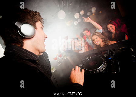 DJ playing music for crowd in nightclub