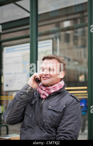 Close-up on man talking and phone and waiting for the bus Stock Photo