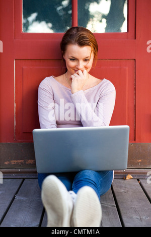 Woman smiling and using laptop Stock Photo