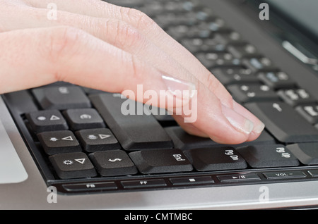 female hand pressing enter key on the laptop Stock Photo