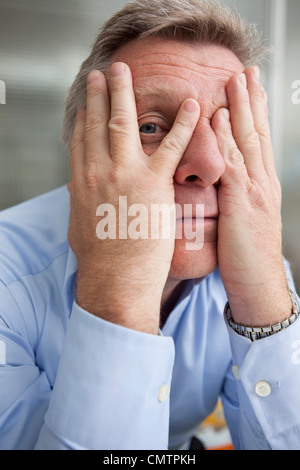 Man holding hands in front of face Stock Photo