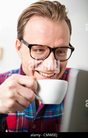 Executive with coffee cup using laptop Stock Photo
