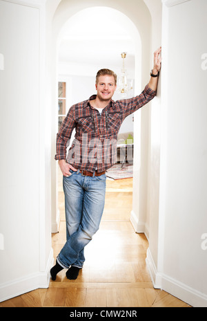 Portrait of mid adult man standing in doorway at home Stock Photo