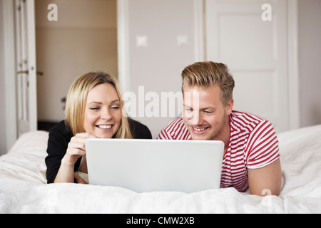 Couple in bed with laptop Stock Photo