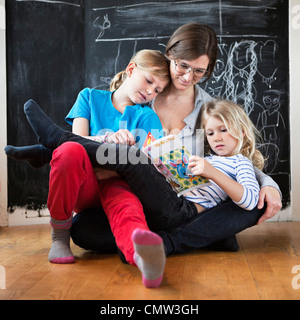 Mother helping her daughters in studies Stock Photo