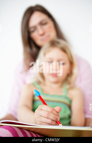 Girl with her mother doing homework Stock Photo