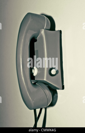 an old house phone hangs on the wall Stock Photo