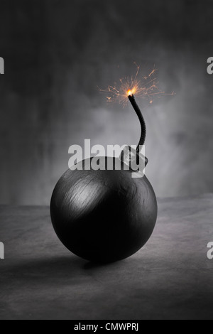 An old fashioned style round bomb with a lit fuse about to explode ...