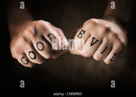 Man with 'Good' and 'Evil' fake tattoos. Stock Photo
