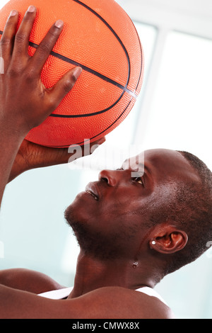 Image of a basketball player throwing ball into basket Stock Photo