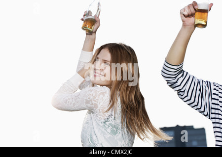 Germany, Cologne, Young couple with beer bottle, smiling Stock Photo