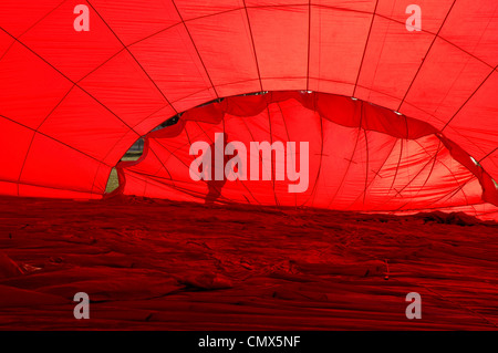 Silhouette of man on the other side of the parachute valve in the crown of a partially inflated Virgin hot air balloon Stock Photo