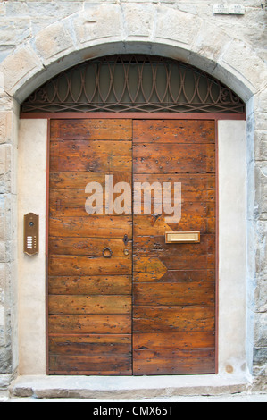Old wooden door in stone arched wall to apartments Stock Photo