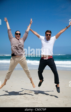 Couple jumping on beach Stock Photo