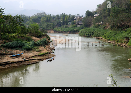 Woman walking across a Bamboo Bridge crossing Nam Khan River Luang Prabang Northern Laos Stock Photo