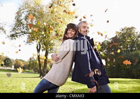 Germany, Cologne, Couple playing in park, smiling, portrait Stock Photo