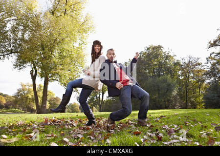 Germany, Cologne, Couple playing in park, smiling, portrait Stock Photo