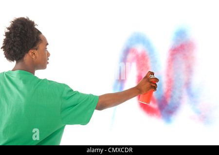 Young black graffiti artist is spraying at the wall Stock Photo