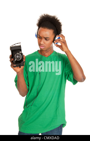 teenager boy is with headphones connecting to vintage photo camera Stock Photo