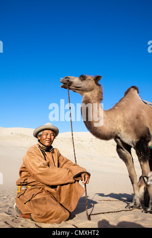 Camel owner take pose in Gobi desert, Khongor sand dune, Mongolia Stock Photo
