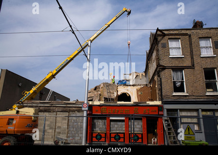 Man during repair work on fire-damaged buildings at Benburb Street in Dublin. Stock Photo