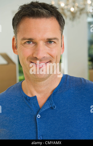 Germany, Bavaria, Grobenzell, Mature man holding model house near ...