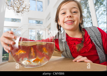 Germany, Bavaria, Grobenzell, Girl with goldfish bowl, smiling, portrait Stock Photo