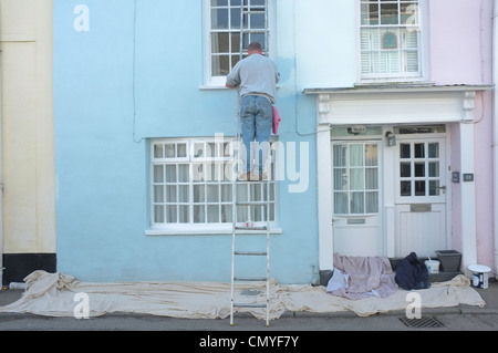 A man decorates a house in Flushing, Cornwall Stock Photo