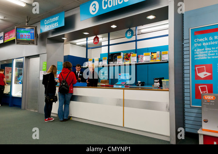 Two customers talking to Customer Services counter in Argos, UK Stock Photo