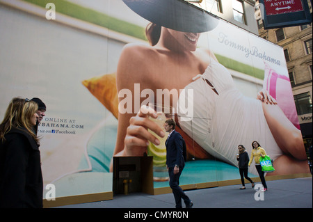 A construction shed decorated by a giant billboard covering the future Tommy Bahama store on Fifth Avenue in NY Stock Photo