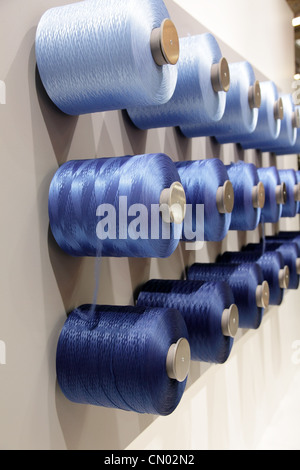 spools with threads hanging on the wall Stock Photo