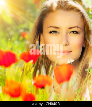 Closeup on beautiful woman face, female enjoying flower field, lovely girl at spring outdoor vacation, floral poppy garden Stock Photo