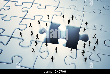 Tiny people walking up to a missing jigsaw puzzle piece Stock Photo