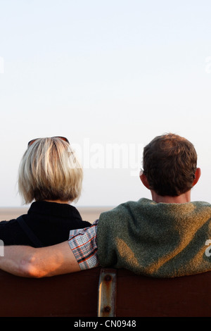 A couple on a bench at sunset Stock Photo