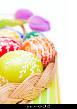 Easter Hand Painted Eggs in Basket on Tablecloth Isolated on White Stock Photo