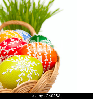 Easter Hand Painted Eggs in Basket and Grass Isolated on White Stock Photo