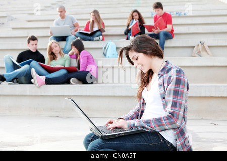 students working with laptops and books on campus Stock Photo