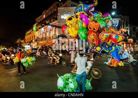 Street traders selling balloons at night. Hanoi, Vietnam. Stock Photo