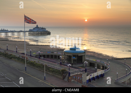 The British union jack flag flying on a flag pole with Eastbourne Pier in the background, East Sussex, England. Stock Photo