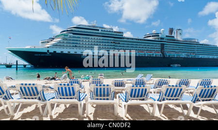 Holland America Line's Nieuw Amsterdam cruise ship at dock in Grand Turk, Caribbean while passengers enjoy the white sand beach Stock Photo
