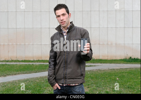 Young man holding Samsung smartphone Stock Photo