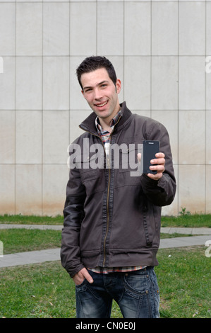 Young man holding Samsung smartphone Stock Photo