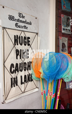 UK, Cumbria, Bowness on Windermere, Huge pike caught in lake newspaper headline next to child’s fishing nets Stock Photo