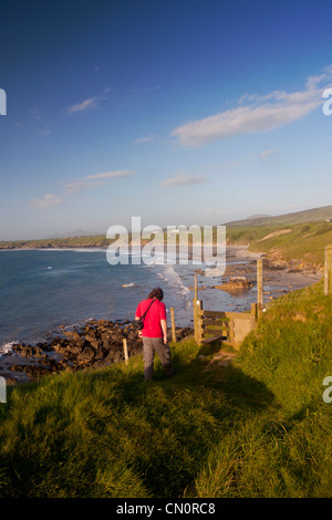 Male walker on Wales Coast Path about to cross stile Traeth Penllech Beach Porth Colmon near Llangwnnadl Gwynedd North Wales UK Stock Photo