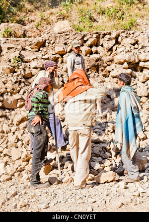 portrait of wall builders along the public foot path to Shiv Kodi hindu temple having a break from breaking rocks Stock Photo