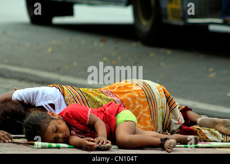 homeless mother and child sleeping on the footpath in Mumbai, India Stock Photo