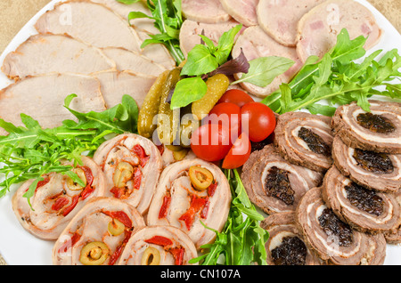 Cutting meat tenderloin with prune with lettuce, tomatoes and Ruccola Stock Photo