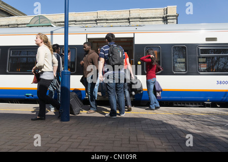People and passengers getting on and off a train at West Brompton Southern Region railway station London UK Stock Photo